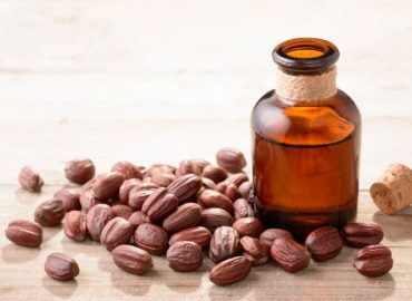 imagine cu jojoba și o sticluță cu ulei